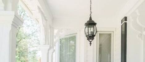 A covered porch with white columns and a hanging lantern.