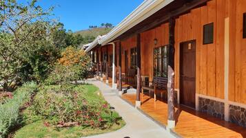 A wooden building with a covered walkway, stone accents, and a bench.