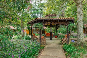 Un jardín con un pabellón, un sendero y zonas de estar.