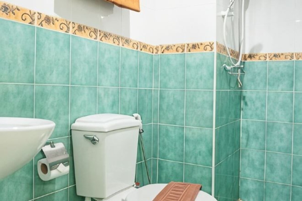 Een badkamer met toilet, wastafel en douche.