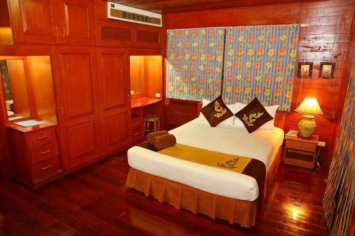Una habitación con paneles de madera, una cama, un escritorio y una silla.