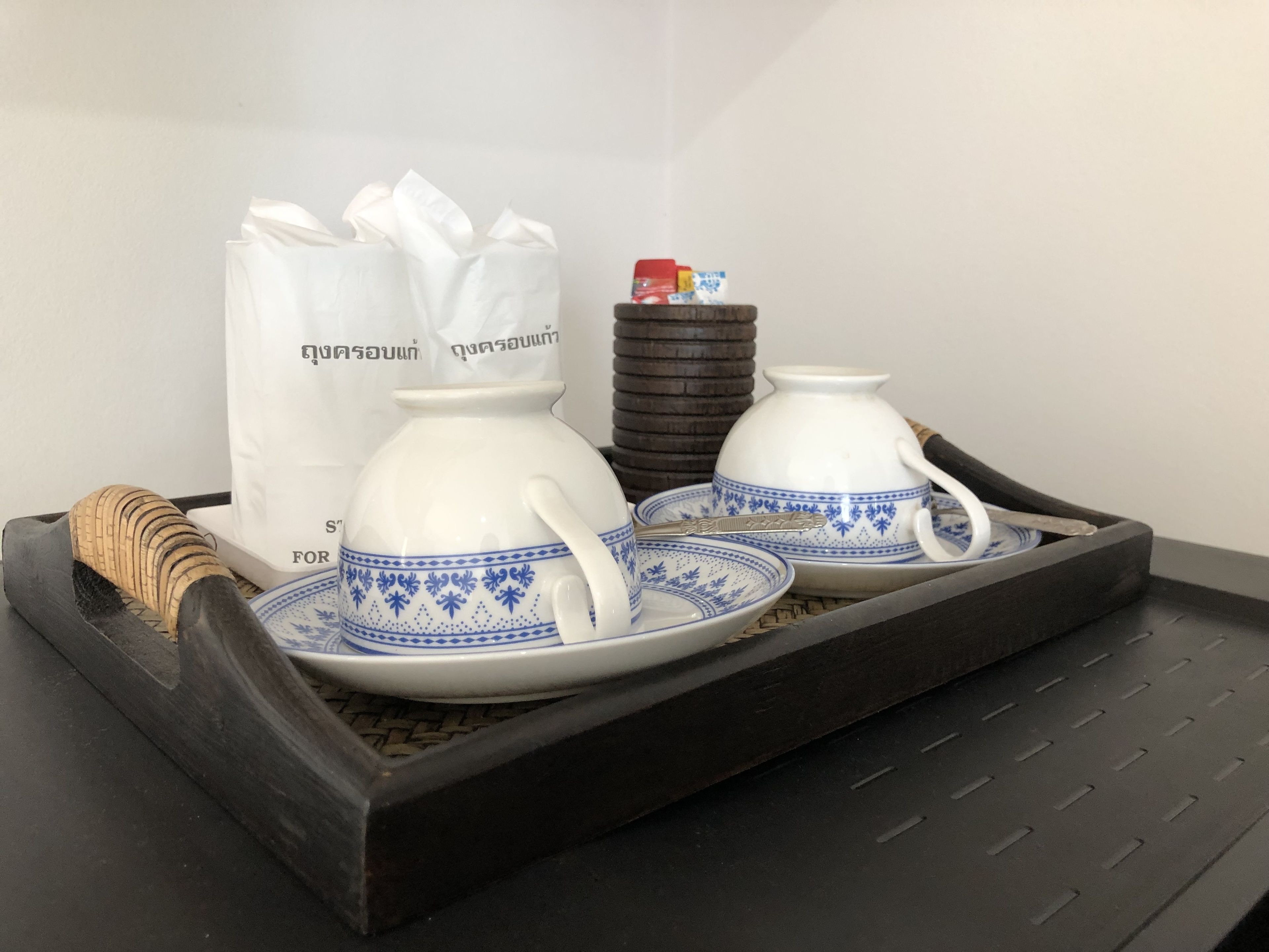 Un plateau avec une théière, deux tasses à thé, un sucrier et une pile de morceaux de sucre.