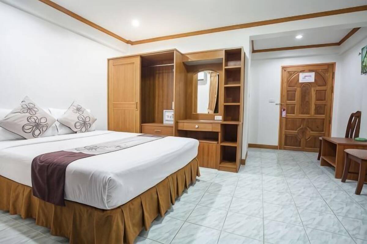 Un dormitorio con cama, armario, escritorio y silla.