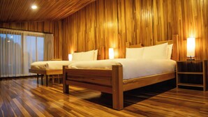 Una habitación con dos camas de madera, suelo de madera y techo de madera.