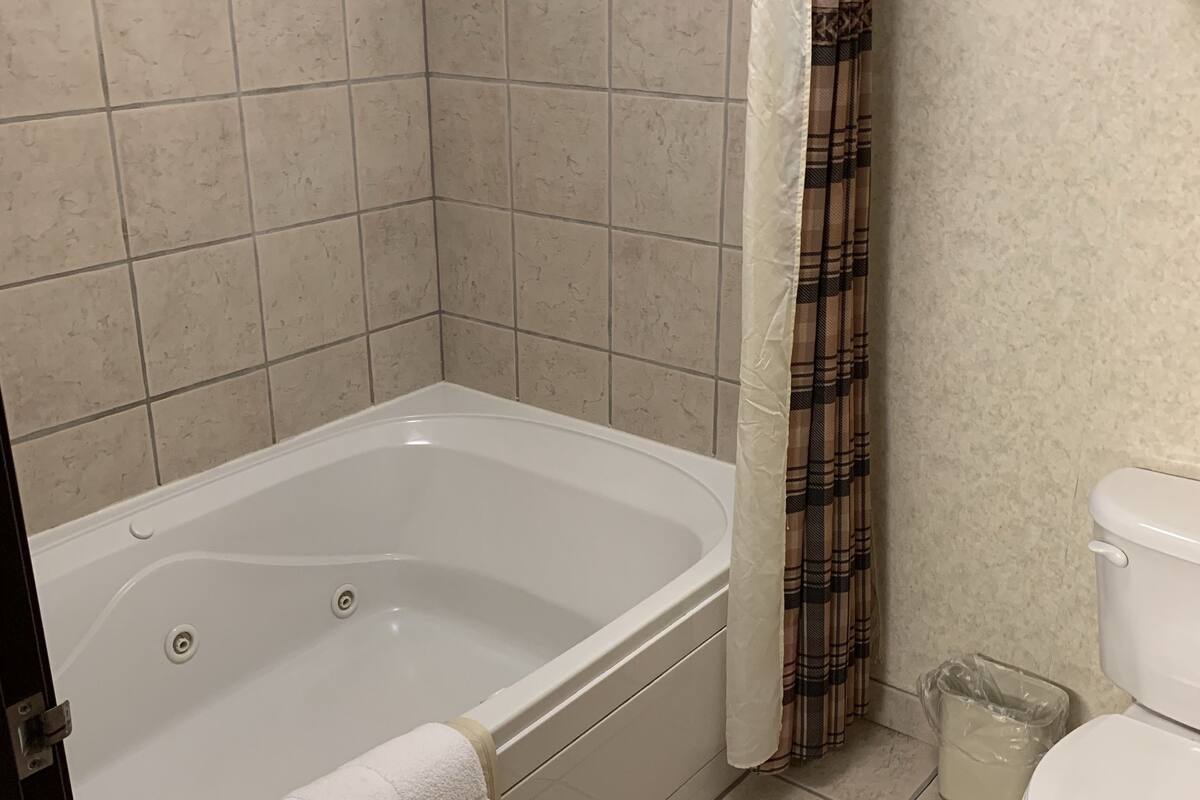 suite, 1 king bed with sofa bed, jetted tub (king suites main floor - jetted tub) | bathroom | combined shower/bathtub, free toiletries, hair dryer, towels
