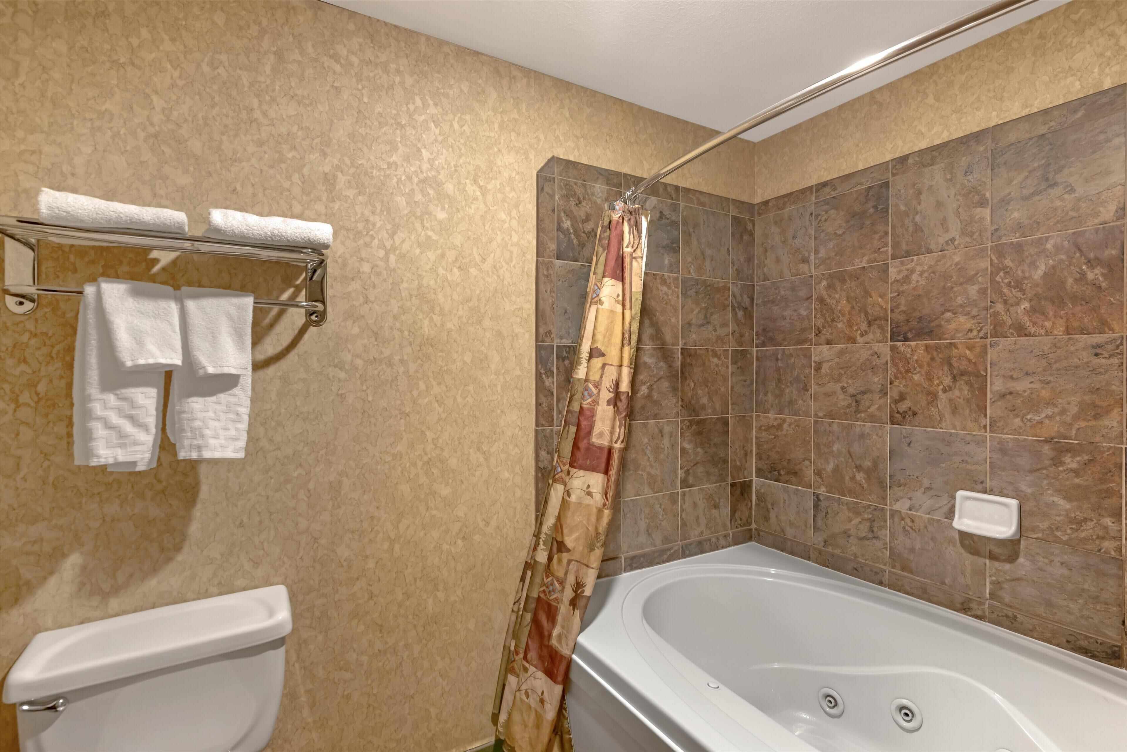 Une salle de bain équipée d’une baignoire, de toilettes et d’un porte-serviettes avec des serviettes.
