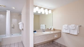 Un baño moderno con bañera, lavamanos y un espejo grande.