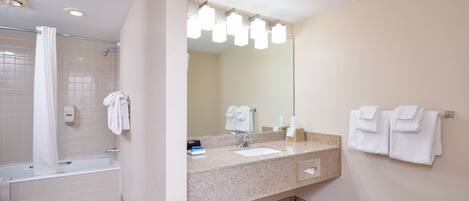 Een moderne badkamer met een bad, een wastafel en een grote spiegel.