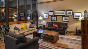 A modern living room with a sofa set, a coffee table, and a rug.