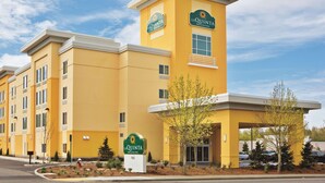 Un bâtiment jaune de la chaîne La Quinta Inn & Suites, avec un ciel dégagé.