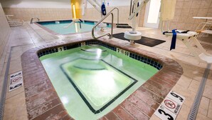 Une piscine avec un plongeoir, un poste de surveillance pour les sauveteurs et un panneau indiquant qu’il est interdit de plonger.