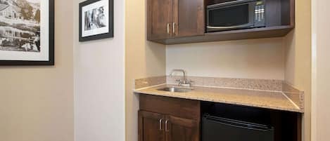 A compact kitchen with a microwave, sink, and dishwasher.