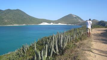 A coastal path with a clear view of the sea and distant mountains.