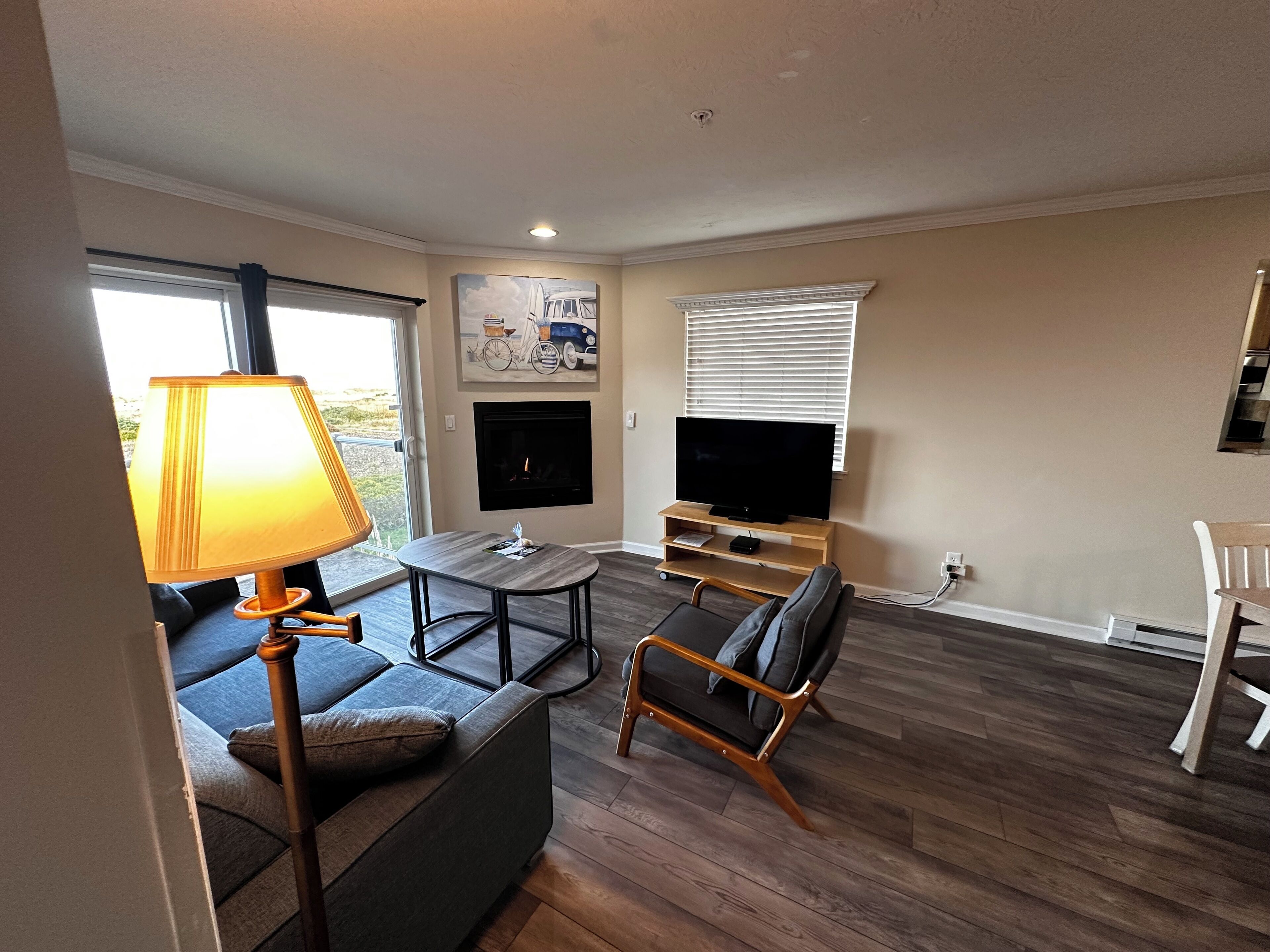 A living room with a sofa, a coffee table, a TV, and a fireplace.