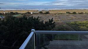 A coastal landscape with a rocky path, grassy areas, and a view of the ocean. - Inn at the Shore (Seaside)