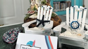 A miniature Christmas tree decorated with seashells and starfish, a small boat with a wheel, and a sign reading "Inn at the Shore". - Inn at the Shore (Seaside)