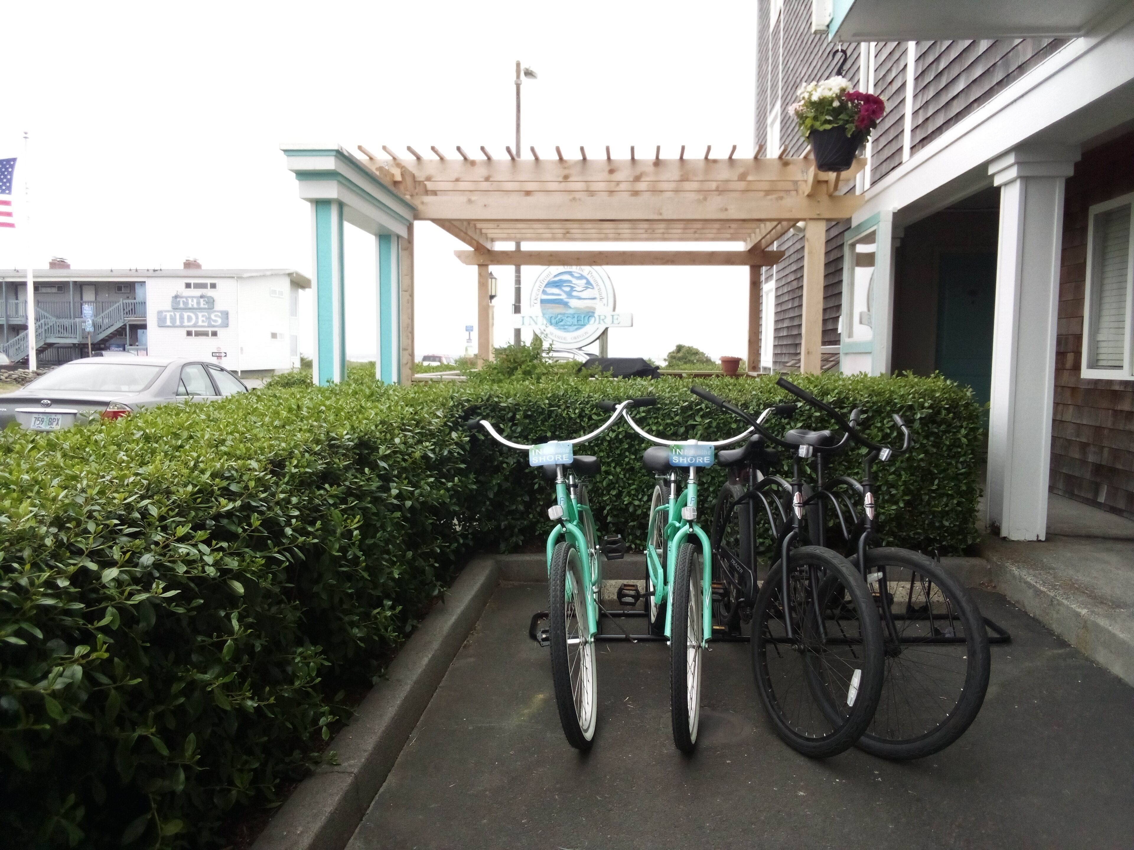 Un espace de stationnement avec des vélos et un bâtiment portant une enseigne indiquant « The Tides ».
