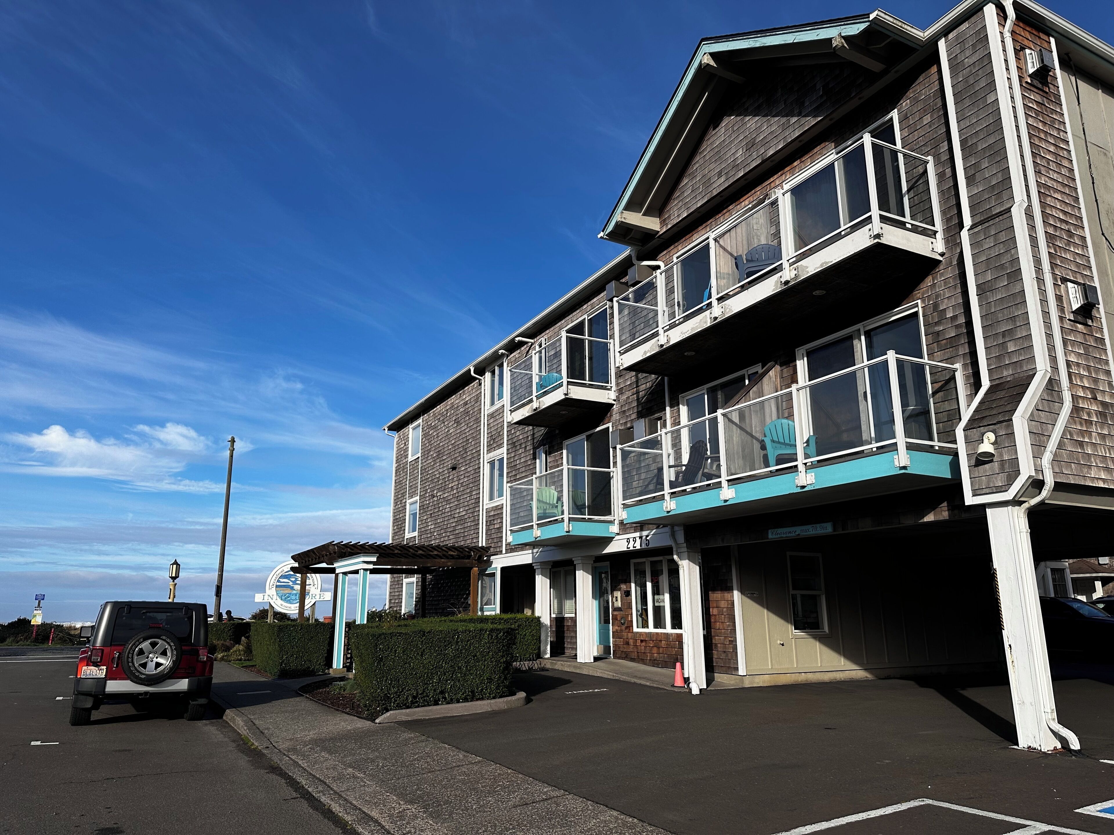 Un immeuble à plusieurs étages doté de balcons et d’un espace de stationnement.