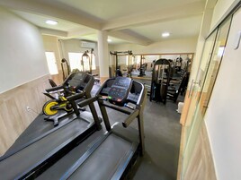 A gym with treadmills, weight machines, and mirrors.