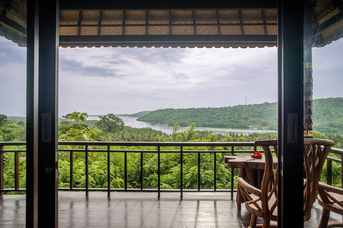 Ein Balkon mit Blick auf einen Fluss und Hügel.