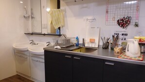 Una cocina moderna con dos fregaderos, una encimera con diversos utensilios de cocina y un espejo sobre el fregadero.
