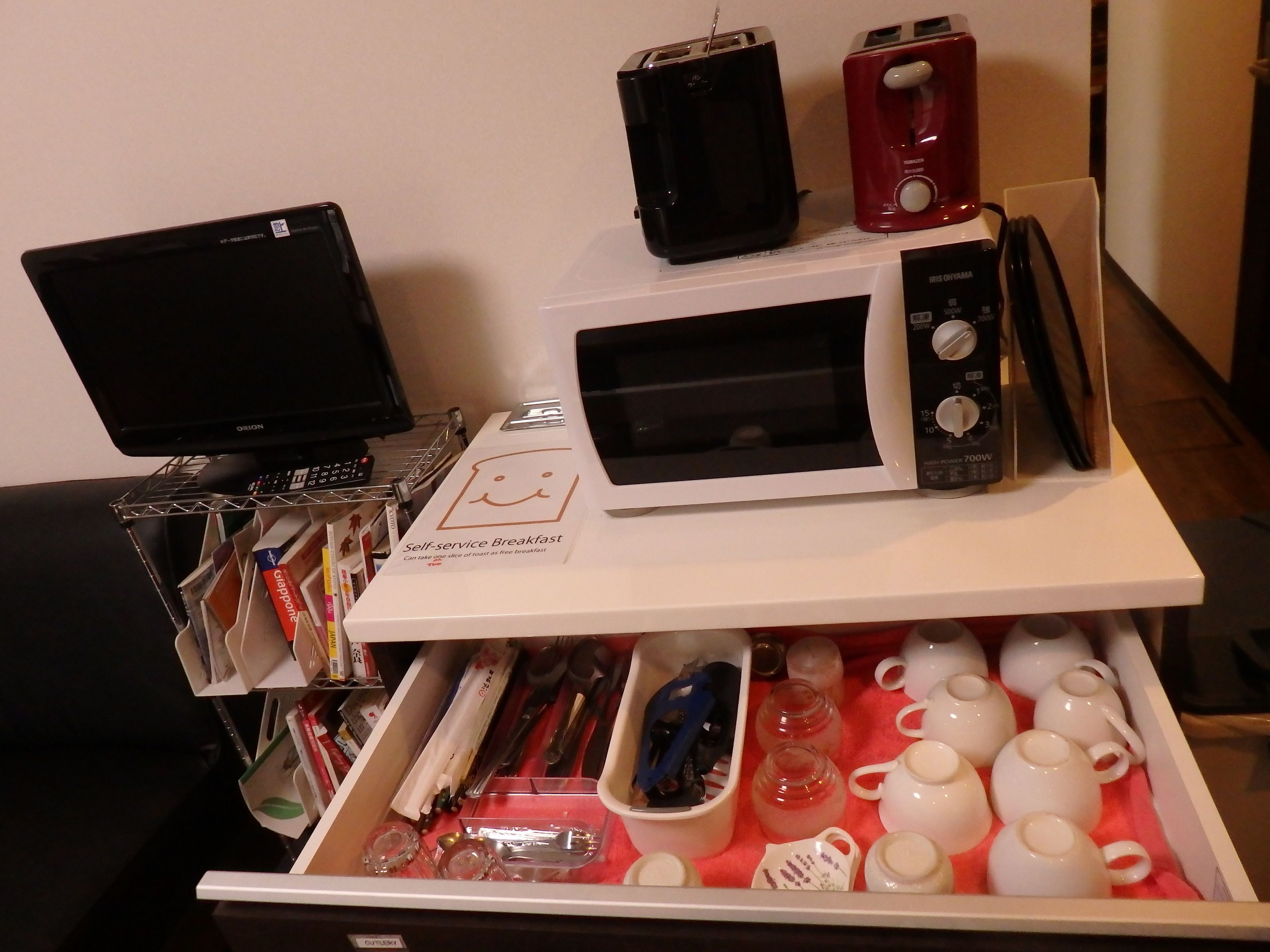 A self-service breakfast station with a microwave, toaster, and coffee maker.