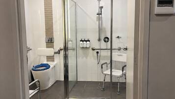 A modern bathroom with a glass-enclosed shower, a white toilet, and a white sink.