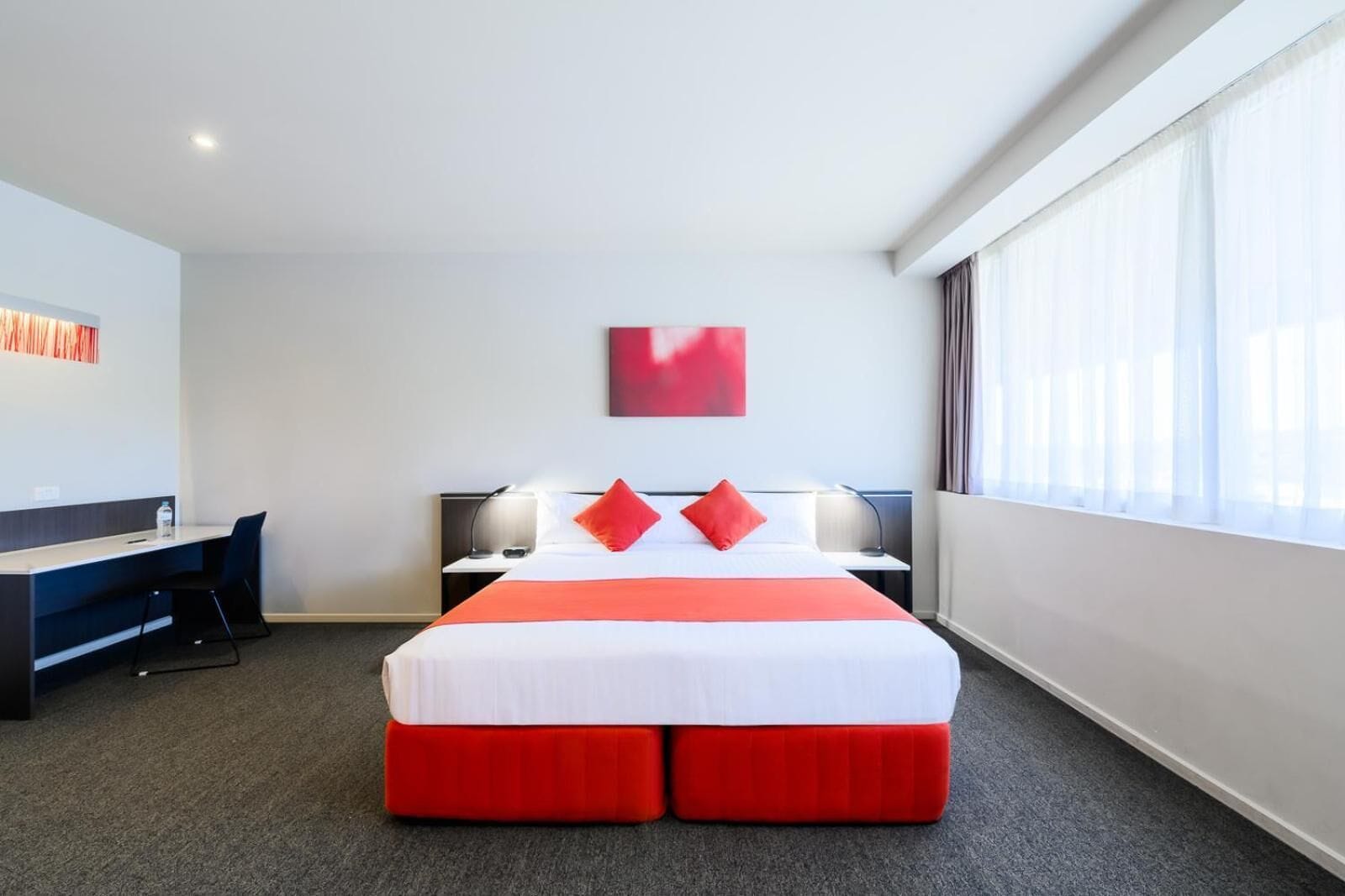Een hotelkamer met een bed, een bureau en een stoel.