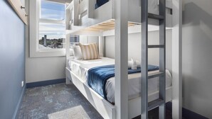 A bunk bed room with a window, a view of the city, and a blue carpet. - Hotel Jesmond (Jesmond)