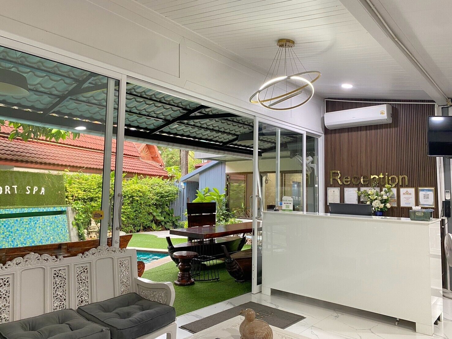 A reception area with a reception desk, a pool view, and a spa sign.
