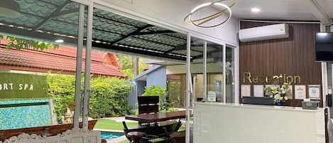 A reception area with a reception desk, a pool view, and a spa sign.