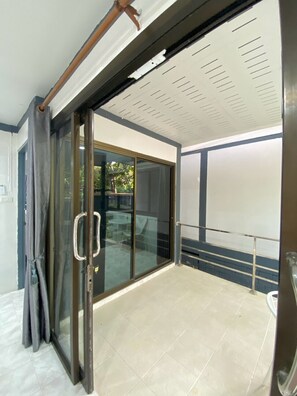 Una habitación con puerta corrediza de vidrio que da a un espacio exterior.