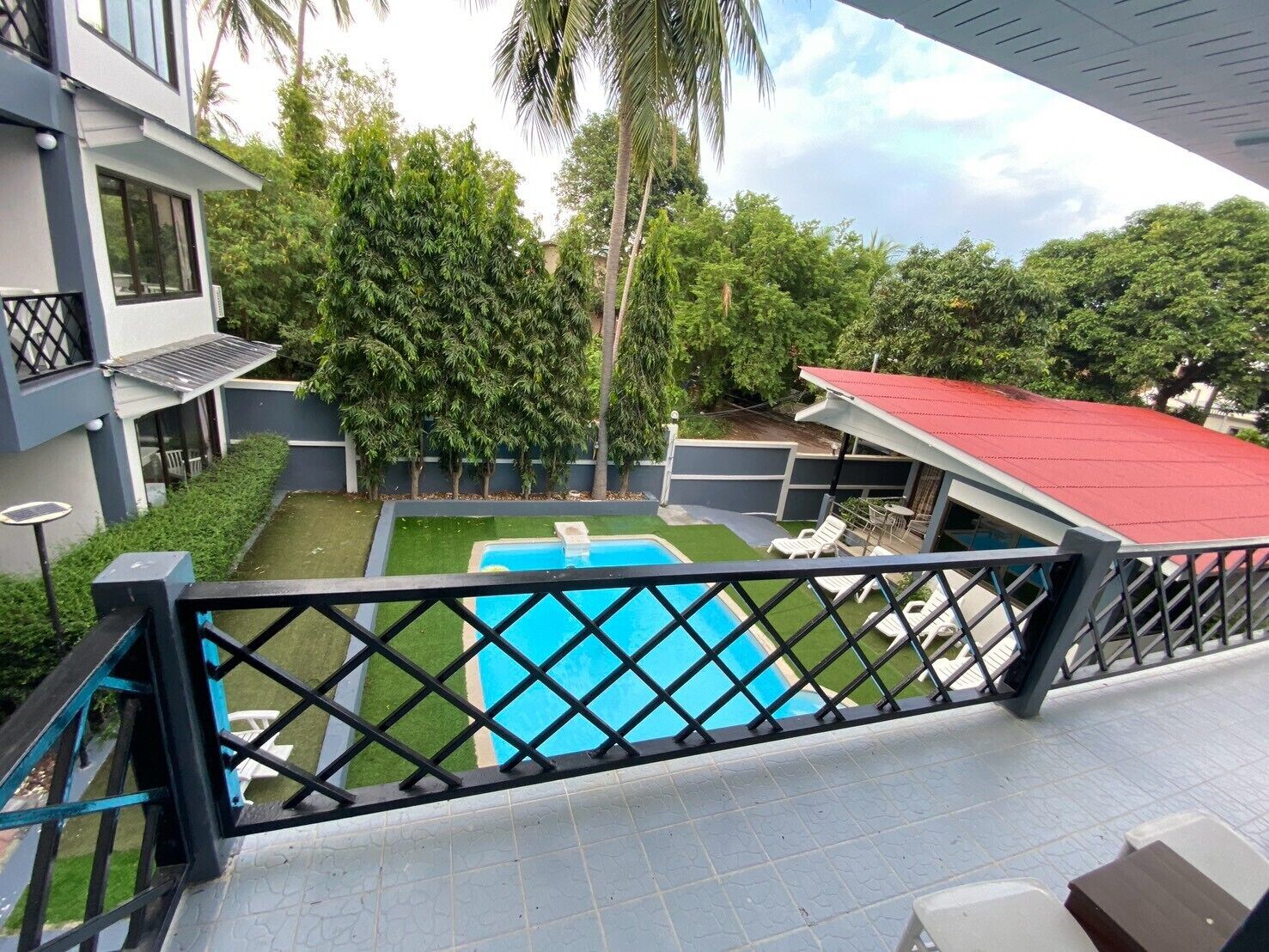 Propiedad residencial con piscina, un patio cubierto y vistas a la vegetación circundante.
