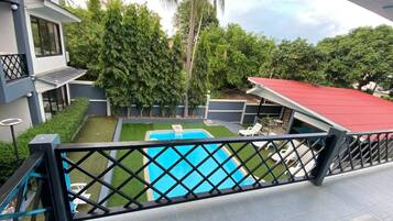 Propiedad residencial con piscina, un patio cubierto y vistas a la vegetación circundante.