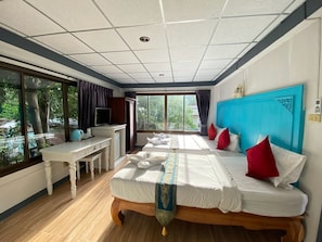 Une chambre d’hôtel avec un grand lit, un bureau et une fenêtre donnant sur l’extérieur.