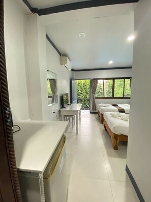 A hotel room with a bed, a desk, a chair, a window, and a bathroom. - Chaweng Noi Resort (Koh Samui)