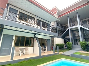 A two-story building with a swimming pool, outdoor seating, and a staircase leading to an upper level. - Chaweng Noi Resort (Koh Samui)