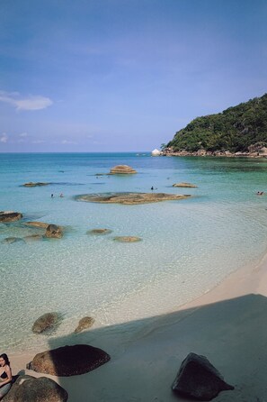 A beach with clear turquoise water, large rocks, and a sandy shore. - Silver Beach Resort (Koh Samui)