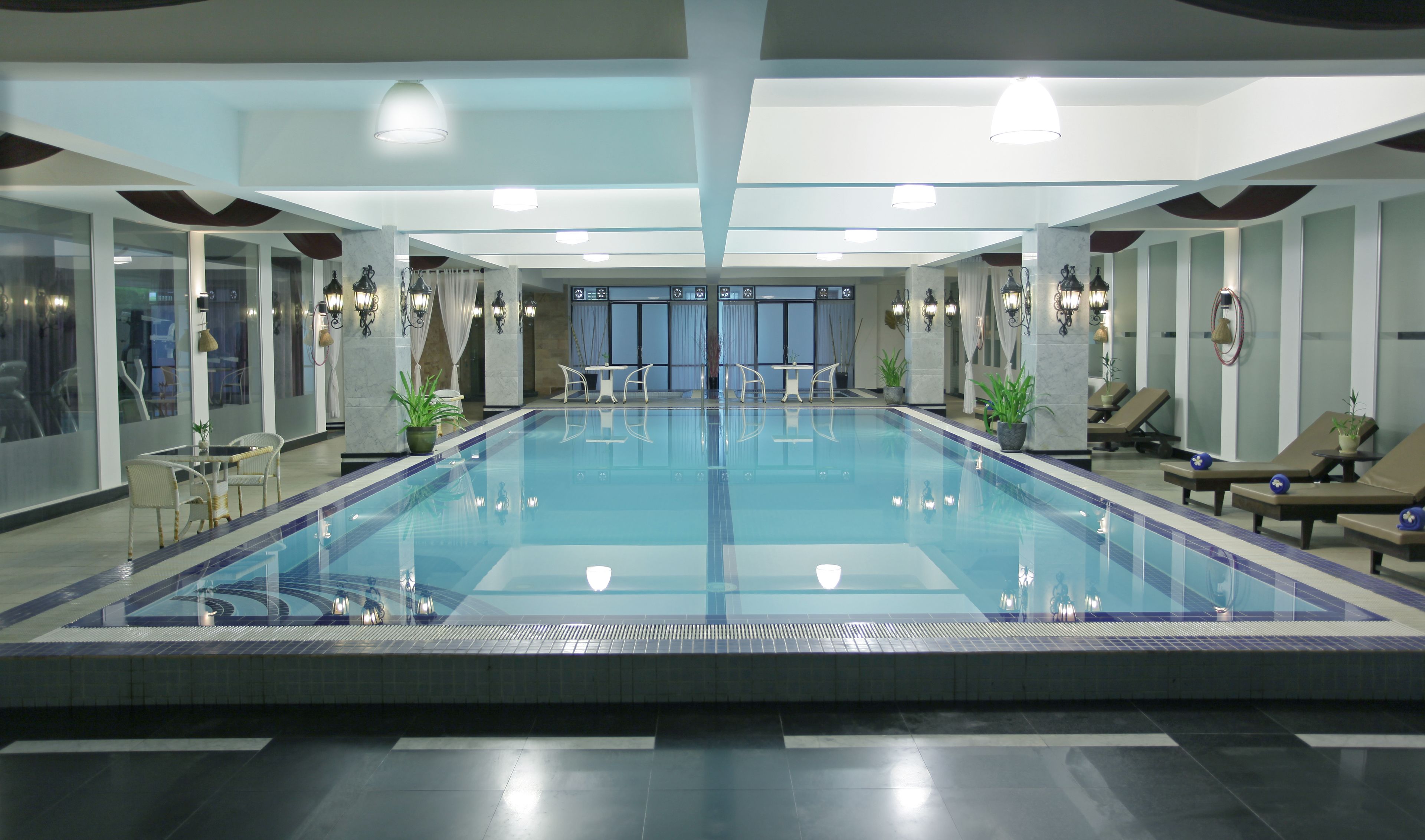 Una piscina cubierta, una piscina al aire libre de temporada, sombrillas