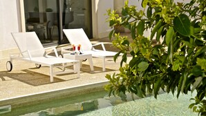 A poolside area with white lounge chairs and a table with two glasses and a bottle. - Hotel del Conte (Fondi)
