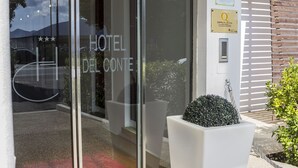 A hotel entrance with a glass door, a sign indicating room number 134, and a welcome mat with the hotel's name. - Hotel del Conte (Fondi)
