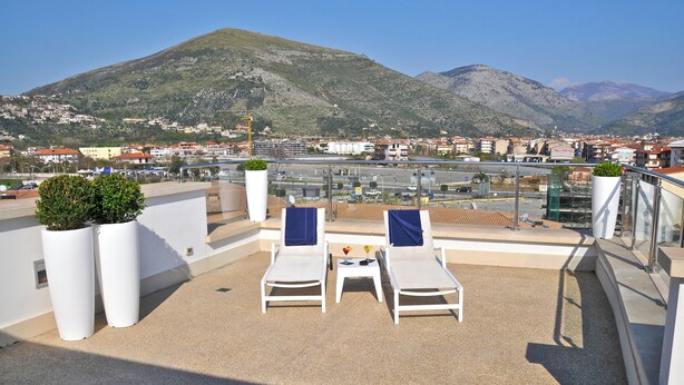 A rooftop terrace with two lounge chairs, a small table, and potted plants. - Hotel del Conte (Fondi)