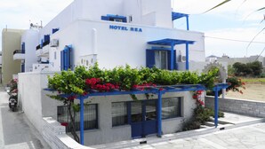A white building with blue accents and the sign "HOTEL REA" on the facade. - Hotel Rea (Naxos)