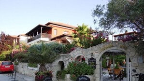 Ein Restaurant mit Außenbereich, Steinmauern und einem steinernen Bogen.