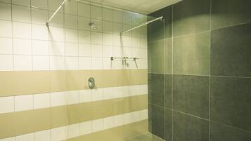 Enjoy a refreshing shower experience with a ceiling-mounted showerhead and convenient towel rack.