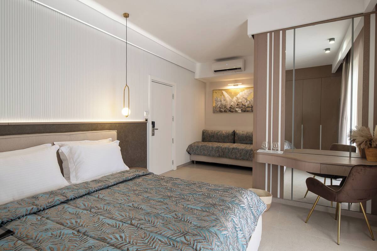 A modern bedroom with a large bed, a desk, and a chair.