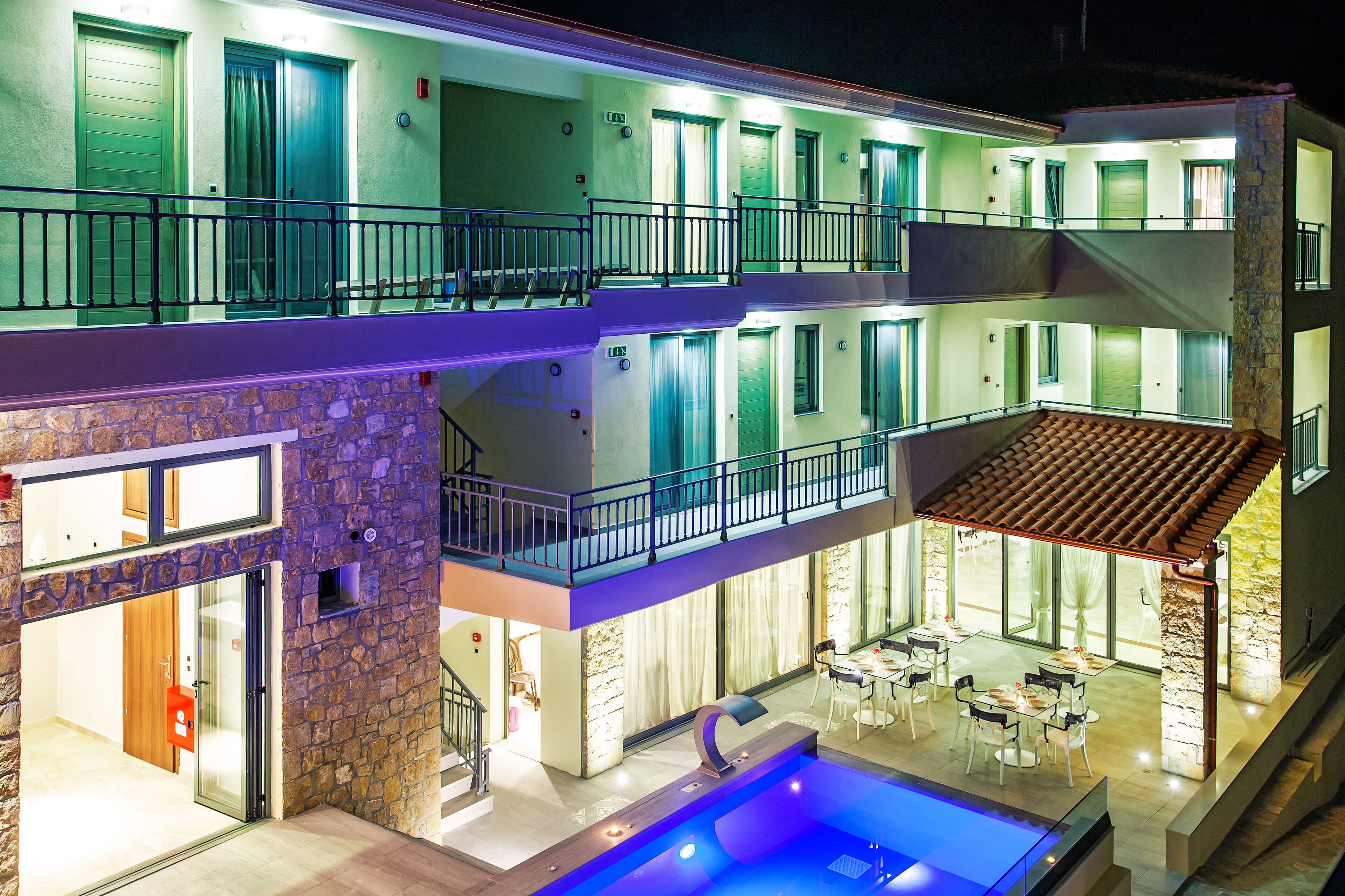 Un hotel de varios pisos con balcones, un área de piscina y un espacio para comer.