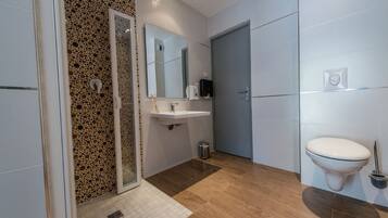Une salle de bain moderne équipée d’une douche, d’un lavabo et de toilettes.