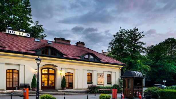A hotel with a red-tiled roof, arched windows, and a sign reading "HOTEL".