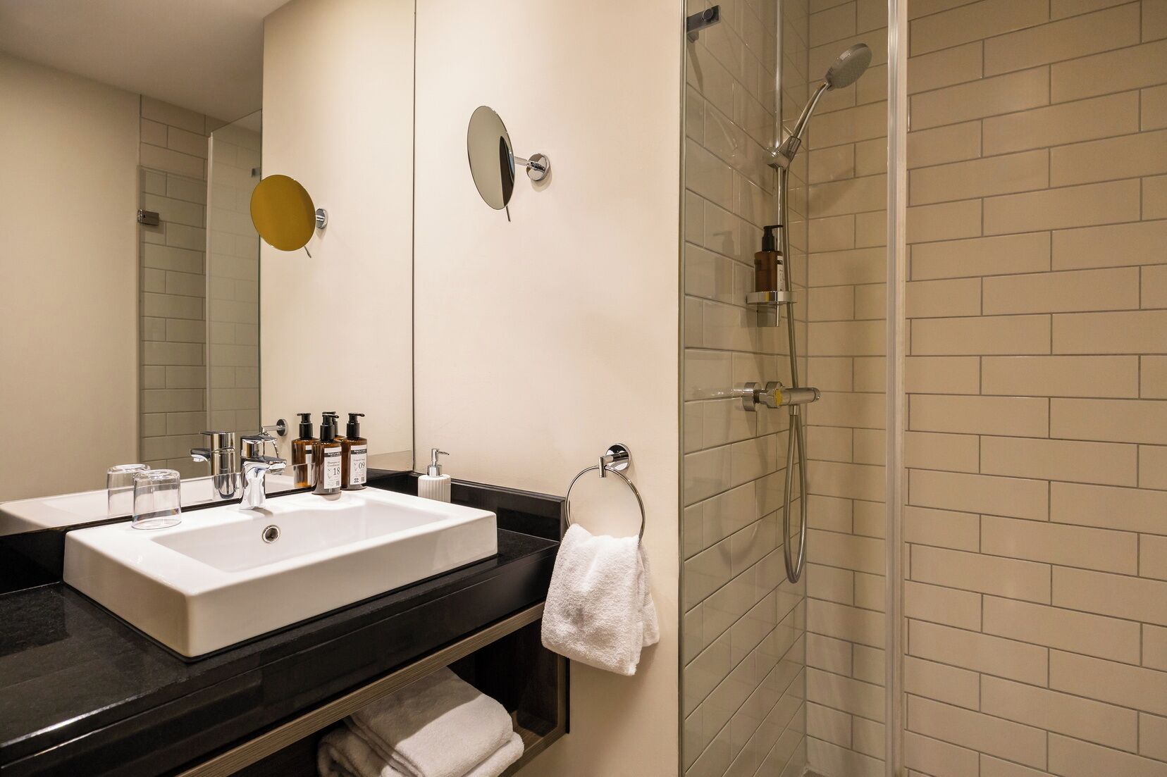 Un baño con un lavamanos grande, espejo y ducha.